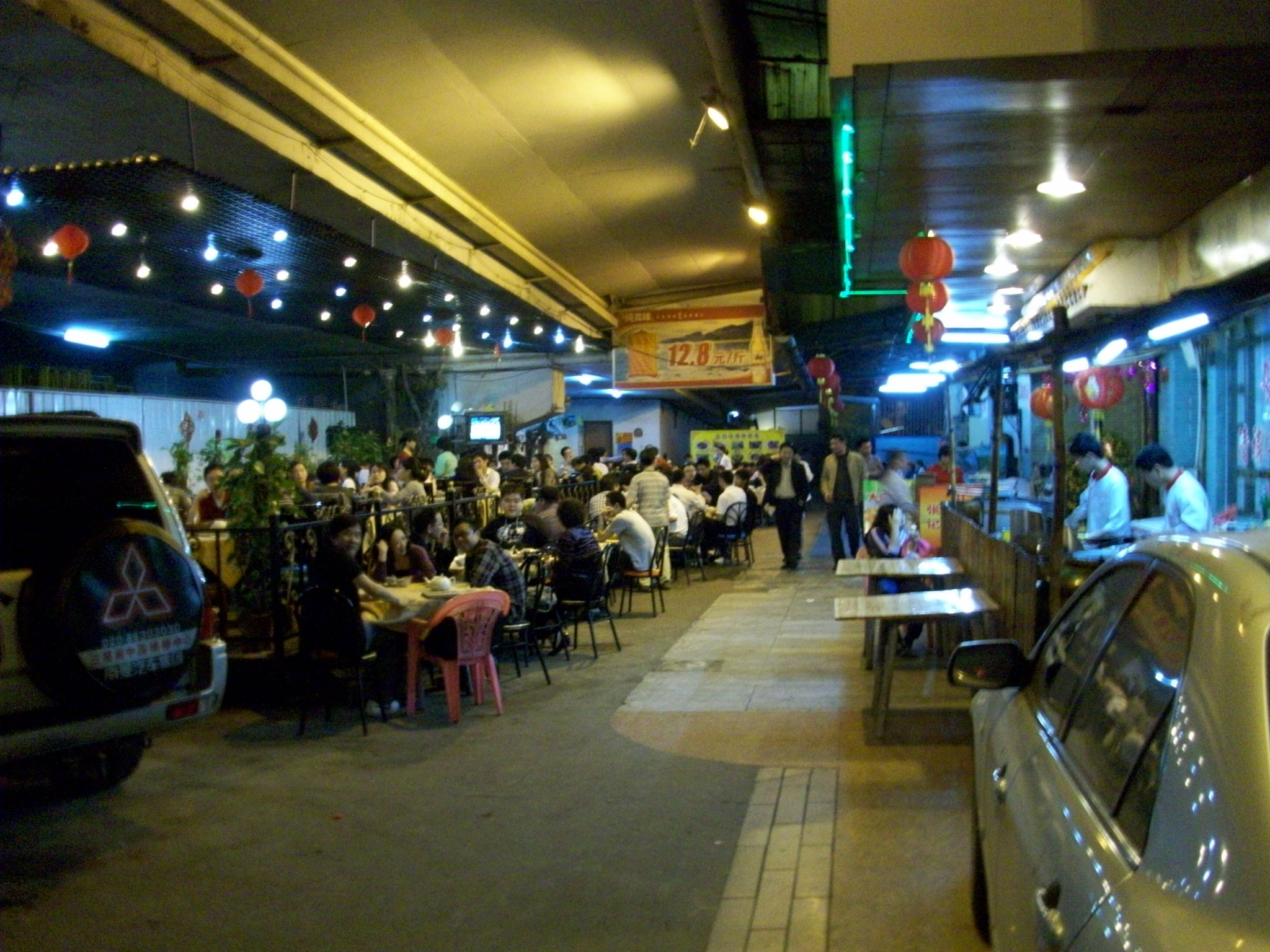 This restaurant sets its tables up on the street under the cover of the highway overpass.